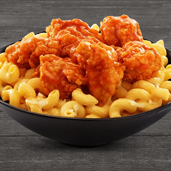 Brown's Chicken buffalo mac and cheese bowl with crispy chicken pieces coated in orange sauce.