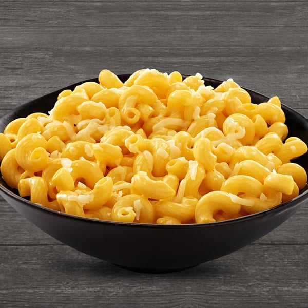 A black bowl filled with creamy, yellow macaroni and cheese, topped with shredded white cheese.